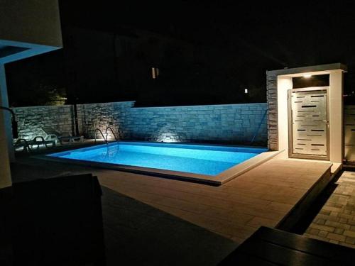 ein Schwimmbad in der Nacht mit einem beleuchteten in der Unterkunft Kuća za odmor MARIA in Vodice