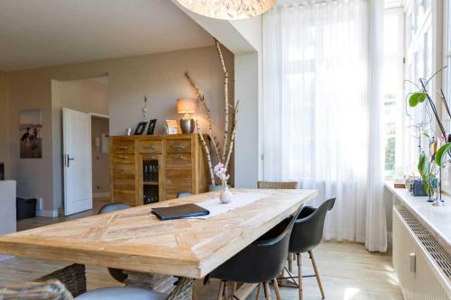 Un comedor con mesa y sillas de madera. en Villa Brunnenstraße, App 2, en Heringsdorf