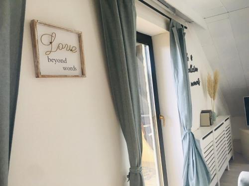 a window with curtains and a sign that says loverend words at Ferienwohnung Brehm in Bad Staffelstein