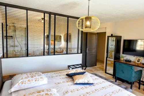 a bedroom with a bed and a large window at Chambre d'hôtes Cottes in Callian