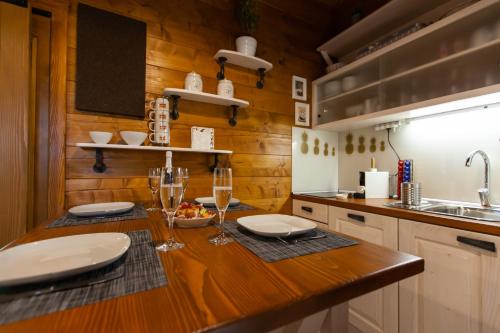 a kitchen with a table with plates and wine glasses at Kuća za odmor Avantura in Vukovo Brdo