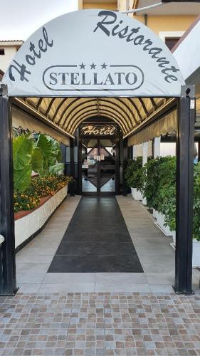a walkway to a building with a sign on it at Hotel Ristorante Stellato in Trebisacce