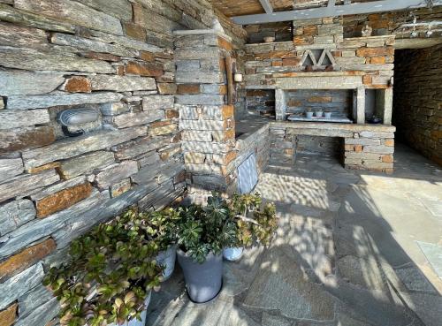 a brick wall with two vases with plants in it at Waterfront villa "Afros" with a pool, direct access to the sea and a small beach in Koundouros