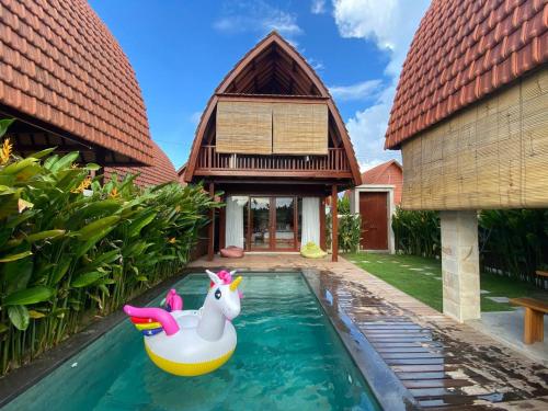 a pool in front of a house with a unicorn in the water at Bhumi Lovina Residence & Villa in Singaraja