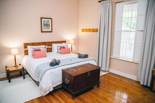 a bedroom with a large bed with pink pillows at Petal's Place in Robertson