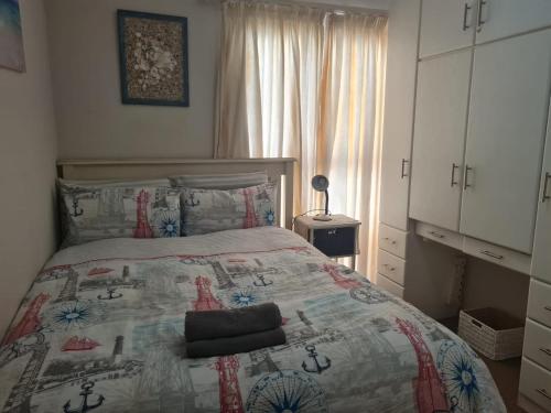 a bedroom with a bed with a quilt on it at Santos 49 in Mossel Bay