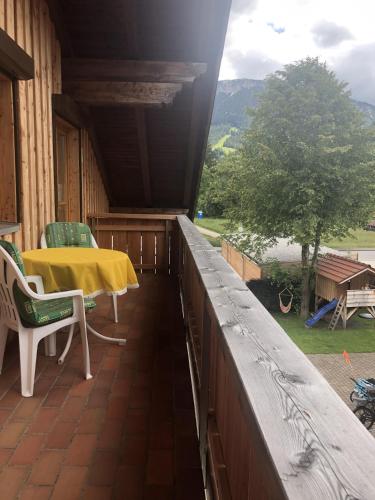 a porch with a yellow table and chairs on it at Ferienwohnung Zweng in Pfronten