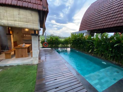 a backyard with a swimming pool and a house at Bhumi Lovina Residence & Villa in Singaraja