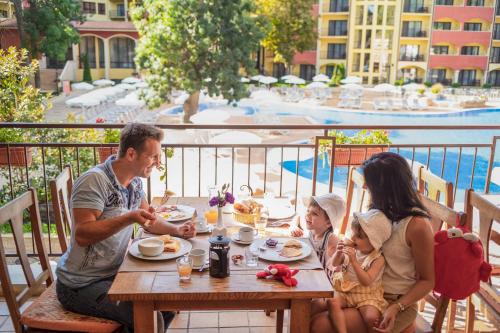 a family sitting at a table eating food at a table at AquaClub GRIFID Hotel Bolero - Ultra All Inclusive & Private Beach in Golden Sands