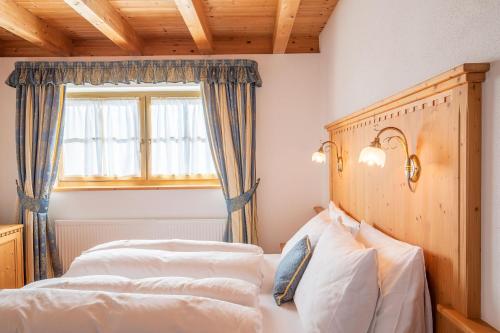 a bedroom with two beds and a window at Cima Dodici B&B - Apartments in Sesto