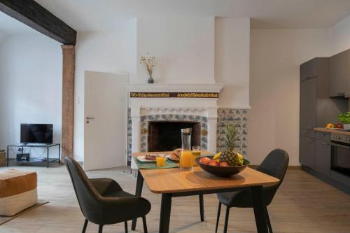 a living room with a table and chairs and a fireplace at Weberhof Ferienapartments in Rostrup am Westufer des Zwischenahner Meers in Bad Zwischenahn