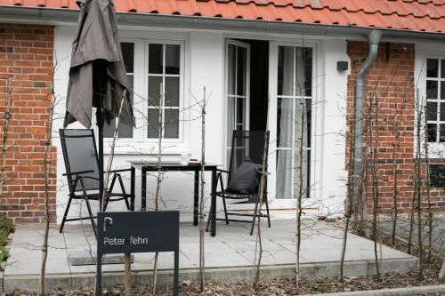 a house with a table and chairs on a porch at Weberhof Ferienapartments in Rostrup am Westufer des Zwischenahner Meers in Bad Zwischenahn