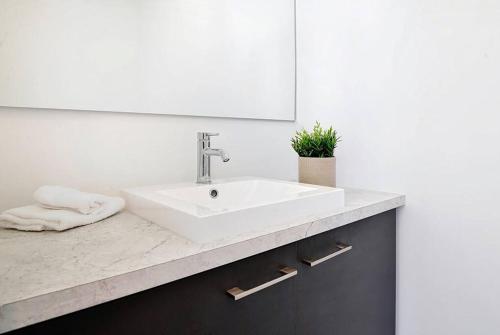 a bathroom with a white sink and a mirror at 15 Chemin des Cascades in Stoneham