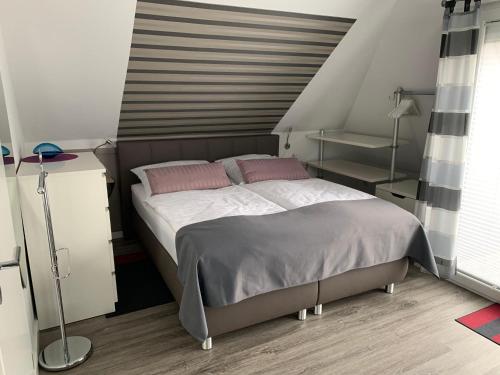ビューズムにあるHaus-Encore-Wohnung-2のベッドルーム1室(ピンクの枕が付いた大型ベッド1台付)