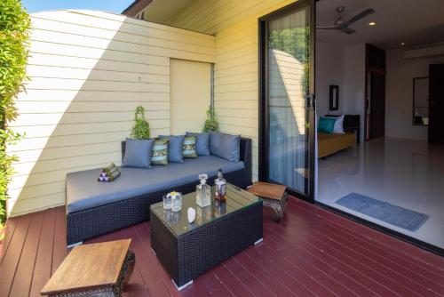 a patio with a blue couch and a table at Moon Cottage in Choeng Mon Beach