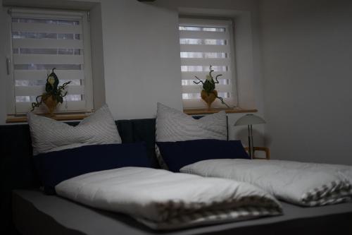 a couch in a living room with two windows at Wandas Domizil mit Whirlpool in Untermerzbach