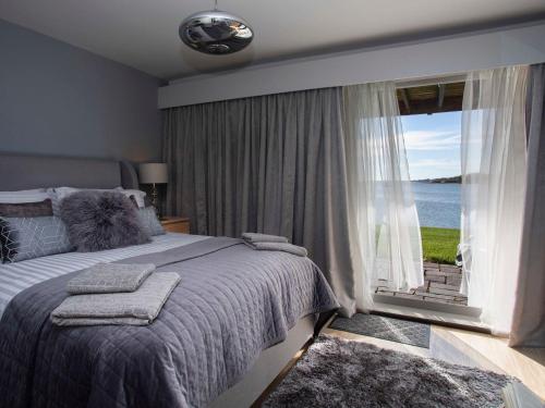 伊費林赫利的住宿－Seaclusion，一间卧室设有一张大床和一个大窗户