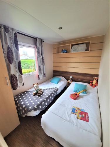 une chambre avec deux lits et une fenêtre dans l'établissement Camping la Plage, à Saint-Hilaire-de-Riez