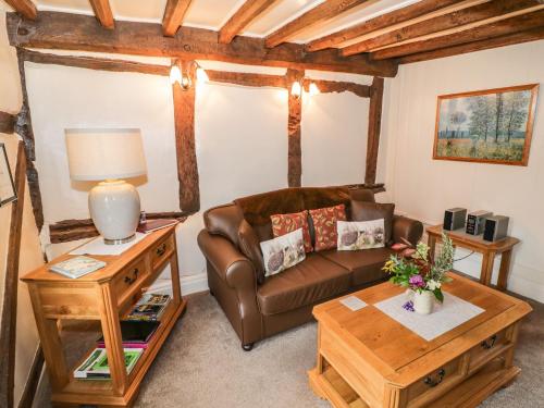 a living room with a couch and a table at Apple Tree Cottage in Evesham