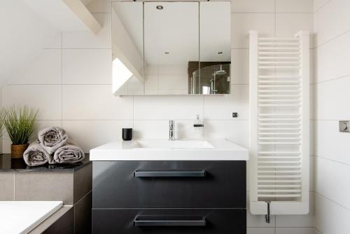 een badkamer met een wastafel en een spiegel bij Julianadorp Zuhause am Meer für 6 Personen mit 4 Schlafzimmern in Julianadorp