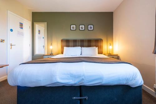 a bedroom with a large bed with white sheets and pillows at Staunton Arms in Staunton in the Vale