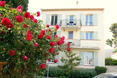 a white building with red roses in front of it at Kimi Résidence in Cannes