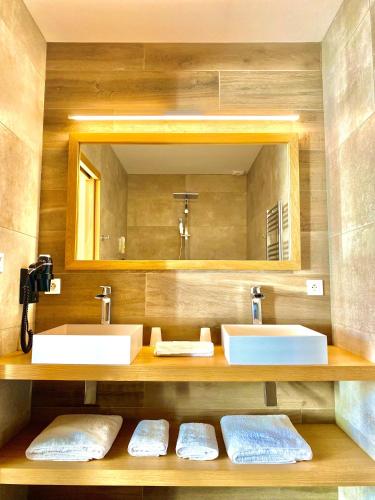 une salle de bain avec deux lavabos et un miroir dans l'établissement La Maison d'Ambrine - La Villa, à Chamaret