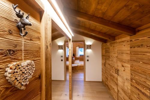 a hallway in a log cabin with wooden walls at iFlat Chalet Carole Ortisei in Ortisei