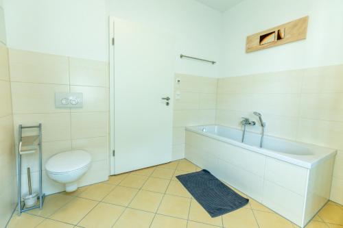 a bathroom with a toilet and a bath tub at Ferienwohnung Jenzigblick in Jena