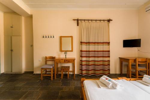 a room with two beds and a table and a mirror at KASTRO AGGELIKI in Kardamyli