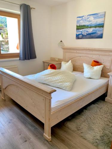 a large wooden bed in a room with a window at Appartmentanlage Isegrim in Altenmarkt im Pongau