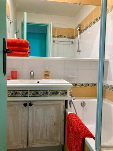 une salle de bain avec un lavabo, une baignoire et un miroir dans l'établissement Les Restanques 2268 glycines, à Grimaud