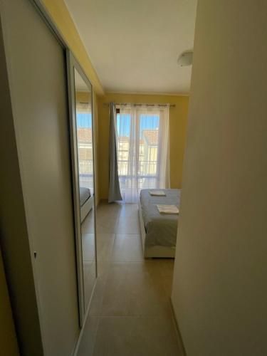 Schlafzimmer mit einem Bett, einem Spiegel und einem Fenster in der Unterkunft B&B Le Rose in Porto San Giorgio