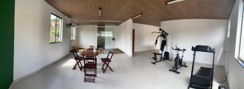 a room with a gym with a table and exercise bikes at Pecafe Hotel in Manhuaçu