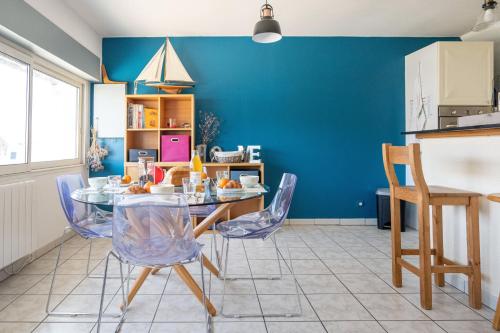 a kitchen with a table and chairs and a blue wall at Ty Bihan in Saint-Potan