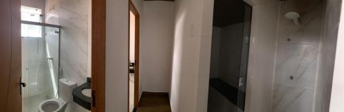 ein Badezimmer mit einem WC und einer Glastür in der Unterkunft Pecafe Hotel in Manhuaçu