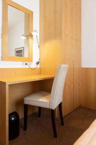 a desk with a white chair and a mirror at Hotel Due Mori in Cittadella