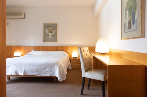 a bedroom with a bed and a desk with a chair at Hotel Due Mori in Cittadella
