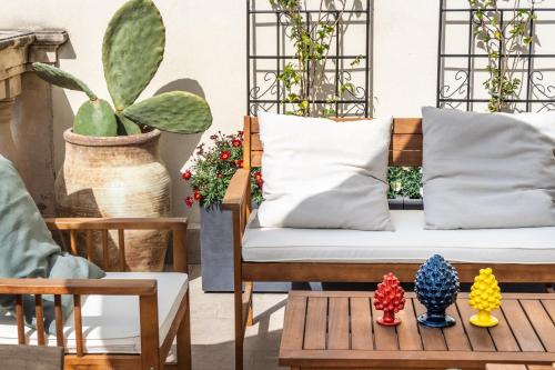 un portico con divano e tavolo con cactus di Guest House Aurispa a Noto