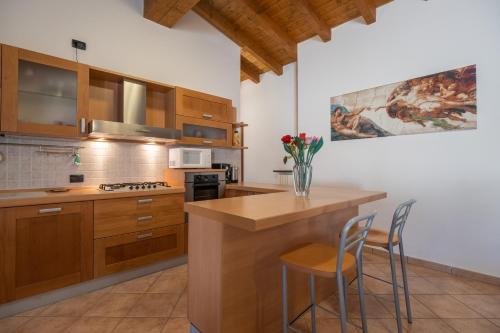 a kitchen with wooden cabinets and a counter with stools at Casa del Gatto in Paratico