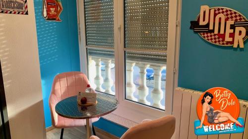 a table and chair in a room with a window at Nos studios au centre ville à Dole in Dole