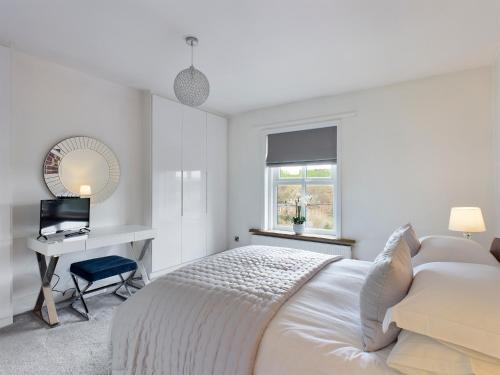a white bedroom with a bed and a desk at THE VIEW! in Delph