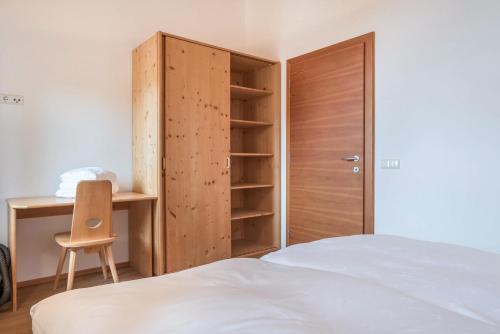 a bedroom with a bed and a wooden closet at Ferienparadies Sabina Birke in Alpe di Siusi