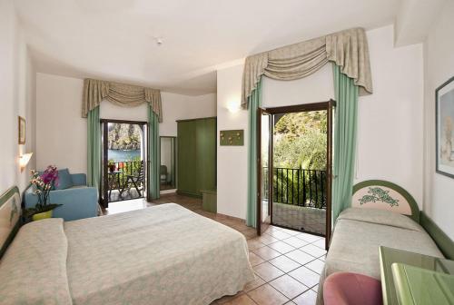 a bedroom with two beds and a balcony at Hotel Gabbiano in Maratea
