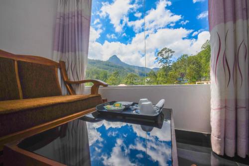 Zimmer mit einem Fenster, einem Tisch und einem Sofa in der Unterkunft Wathsala Inn in Nallathanniya