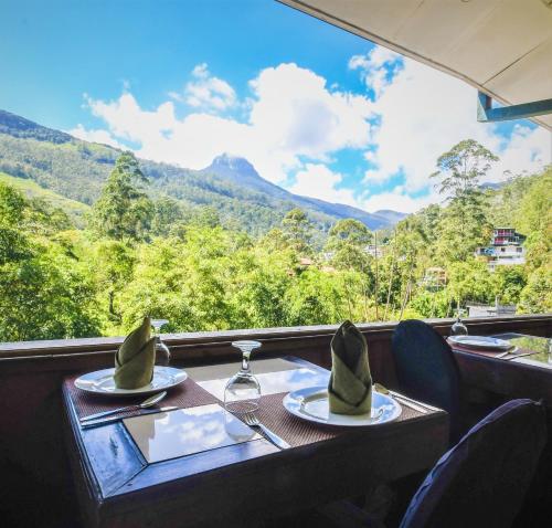 una mesa con dos platos de comida y vistas a las montañas en Wathsala Inn, en Nallathanniya