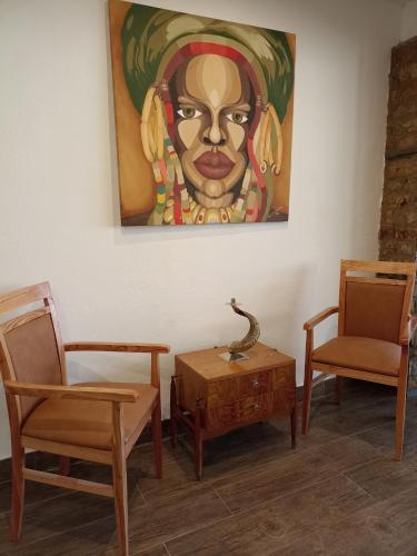 a room with chairs and a painting on the wall at Uspallata Suites in Uspallata