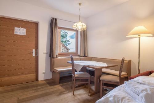 a room with a table and chairs and a window at Ferienparadies Sabina Spitzbühl in Alpe di Siusi