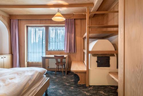 - une chambre avec des lits superposés et un bureau dans l'établissement Ferienparadies Sabina Spitzbühl, à Alpe di Siusi