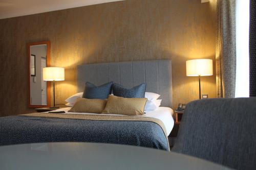 a bedroom with a large bed with blue pillows at Downings Bay Hotel in Downings